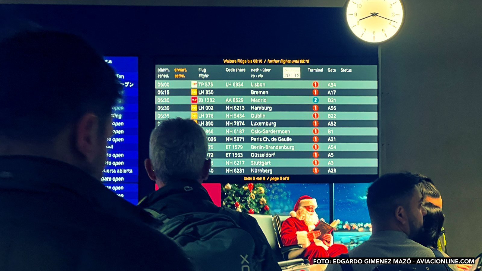 Pasajeros mirando el panel de vuelos en el aeropuerto de Frankfurt, Alemania